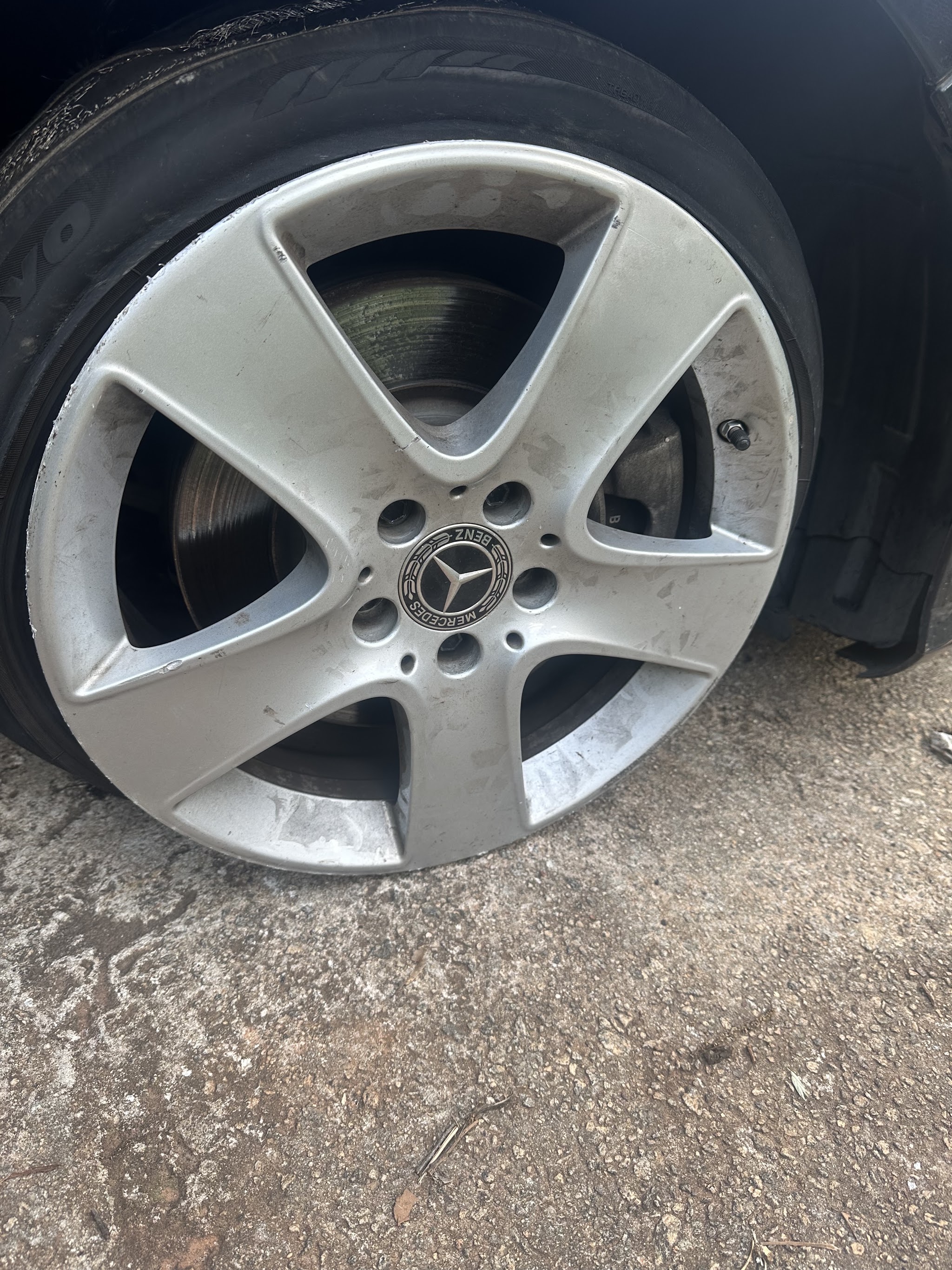 A silver alloy wheel with a fresh tire on a customer's car
